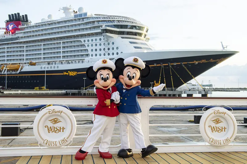 Mickey e Minnie capitães ao lado do casco do navio