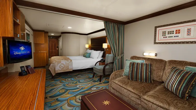 Suíte com sala de estar, sofá e cama ao fundo